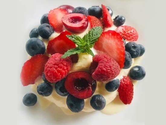 crispy meringue pavlova with berries and cherries