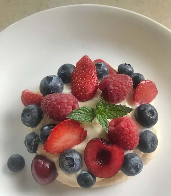 crispy meringue pavlova with berries and cherries