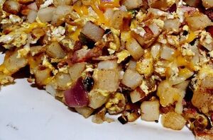 This filling breakfast hash recipe has it all: potatoes, sausage, bacon, eggs, cheese, and even vegetables