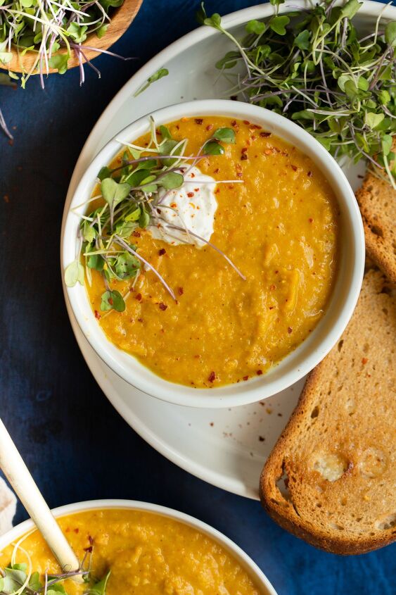 vegan parsnip and carrot soup, Topped with fresh micro greens dairy free yogurt and chili flakes