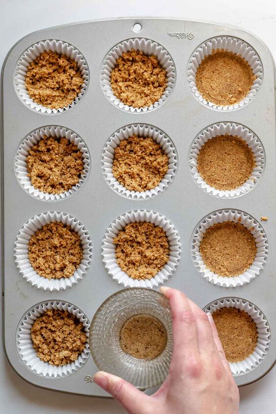 mini strawberry cheesecake cups, Press down the crumbs into the muffin tin to compact