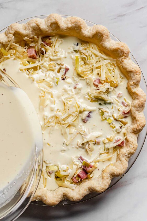ham and swiss quiche with frozen or homemade crust, Custard being poured into the filling