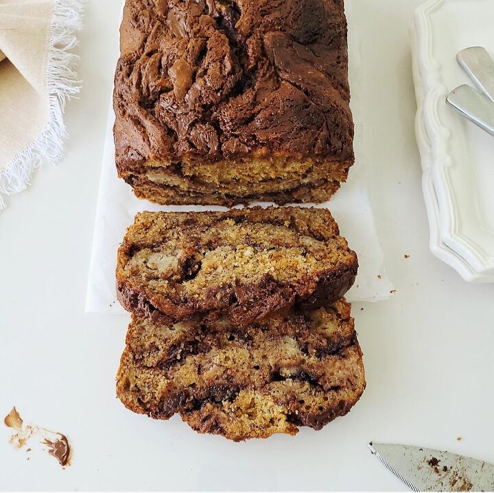 nutella banana bread, functional image nutella banana bread top down view with two slices cut a dirty knife and white places with scalloped edges