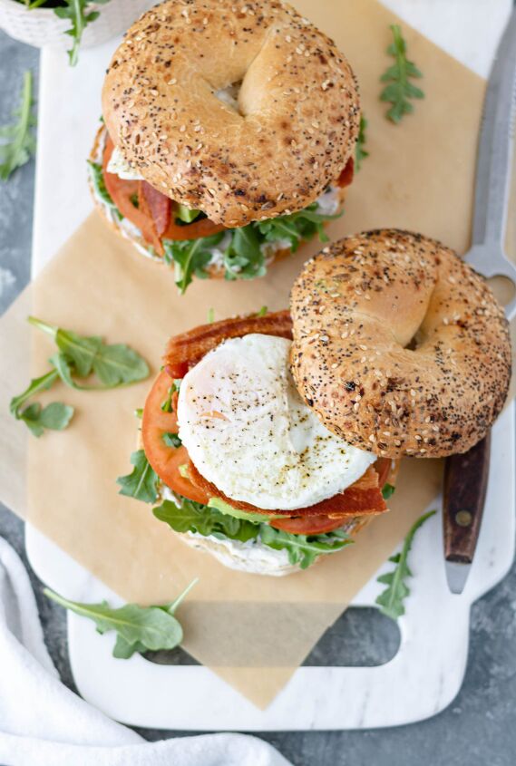 blt fried egg bagelwich, Two BLT Fried Egg Bagelwich sandwiches sitting on a piece of parchment paper