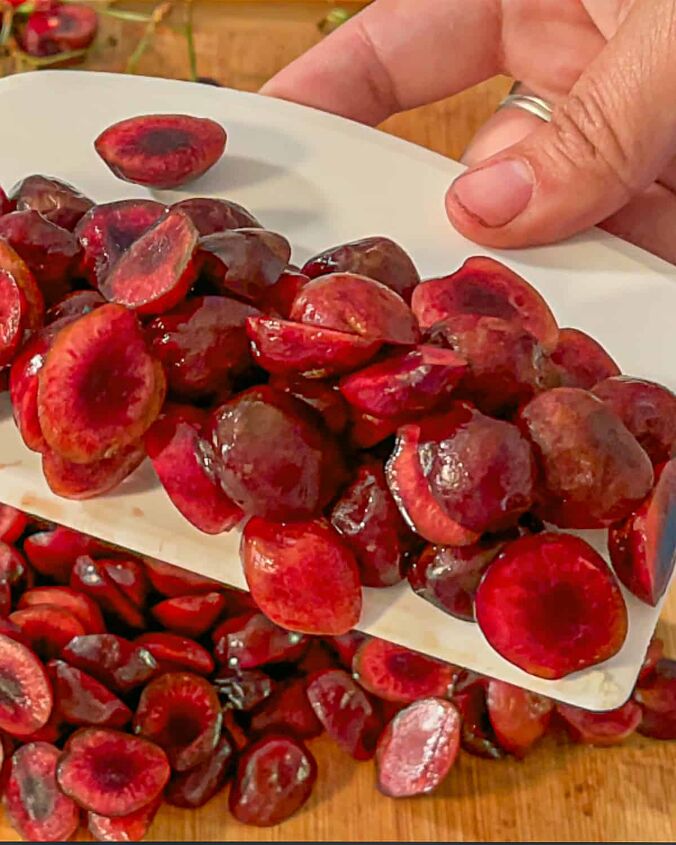 how to dehydrate cherries, peson scooping up cherry slices with a bench scraper