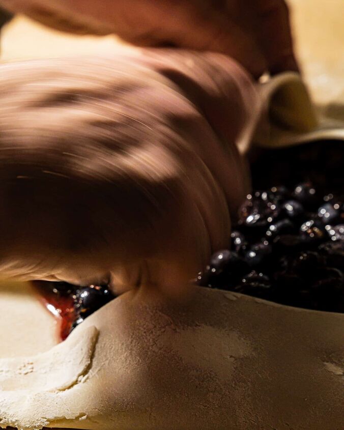 easy blueberry galette, person folding over galette dough edges over