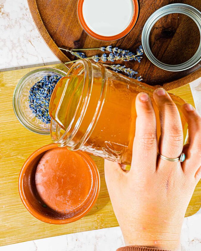 lavender infused herbal honey, person pouring raw honey on to dried lavender flowers in a mason jar