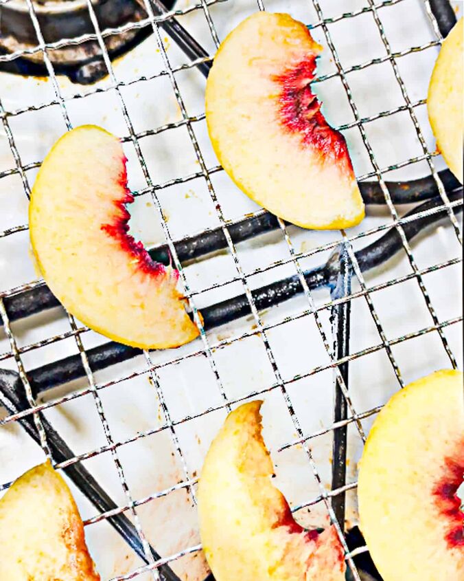 how to dry peaches in a dehydrator, peach slices on a metal rack on a one