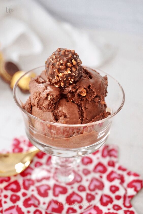 A glass bowl filled with Ferrero Rocher Ice cream in a pretty glass dish with a ferrero chocolate on top