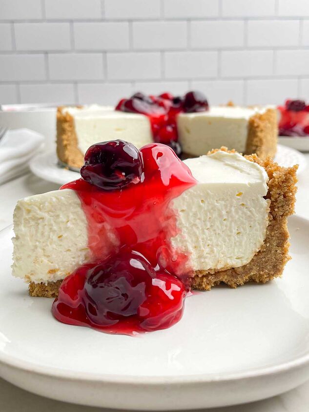no bake cheesecake with cool whip, a piece of no bake cheesecake on a white plate with cherry topping