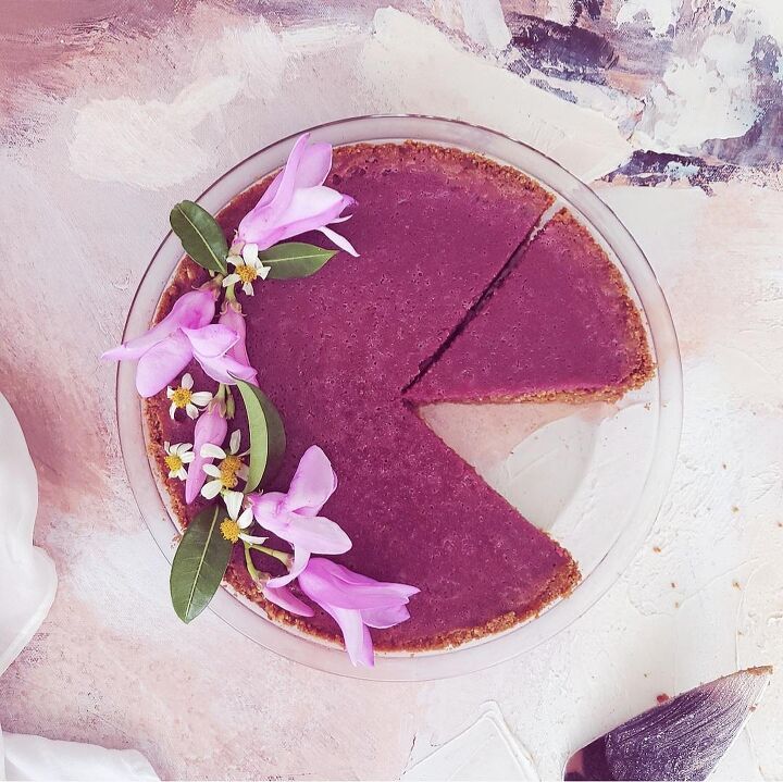 purple sweet potato pie, functional image purple sweet potato pie top down with purple flowers one slice missing from the pie place and other slice cut background is abstract canvas