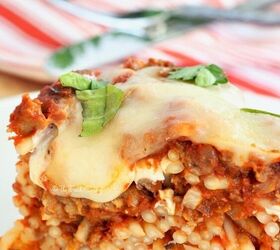 easy baked spaghetti pie, Close up of melty cheese baked spaghetti pie on white plate with meat sauce