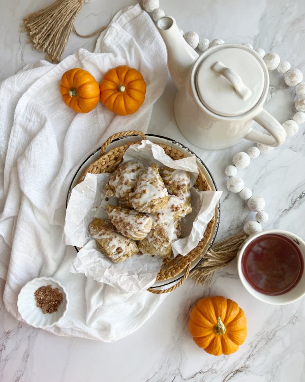 pumpkin scones with glaze and candied pecans, pumpkin scones flatlay with teapot and pumpkins