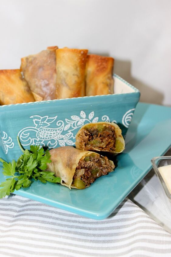 the best philly cheesesteak eggrolls recipe, philly cheesesteak eggroll on a blue plate
