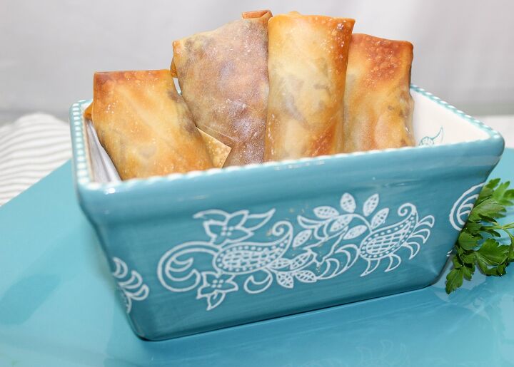 the best philly cheesesteak eggrolls recipe, philly cheesesteak eggroll on a blue plate