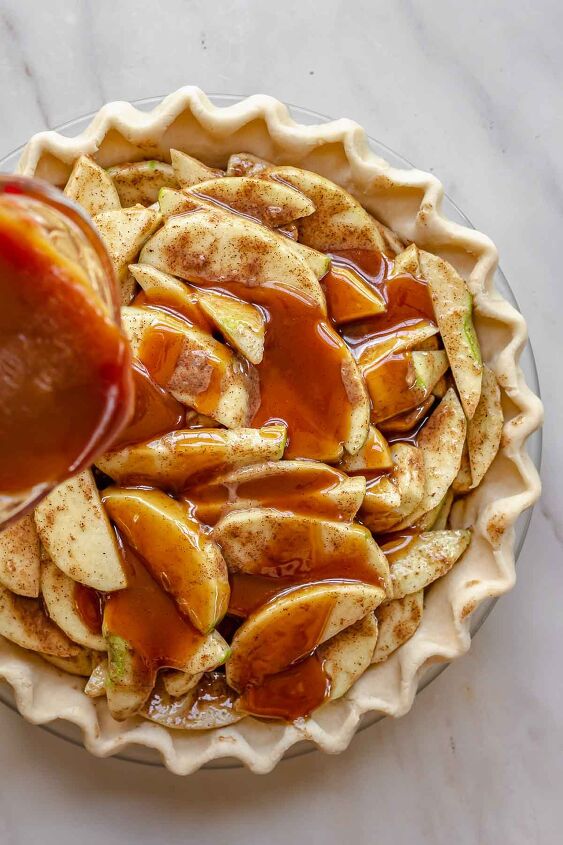 dutch caramel apple pie with crumb topping, Salted caramel pouring over apples in a pie dish