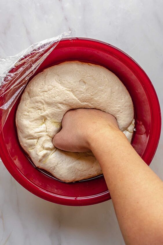 homemade pepperoni bread, A hand punches down risen dough in a bowl