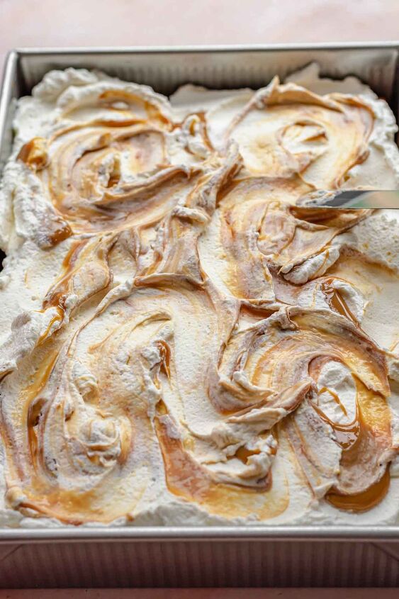 caramel tres leches cake, A spatula swirls caramel into the whipped cream