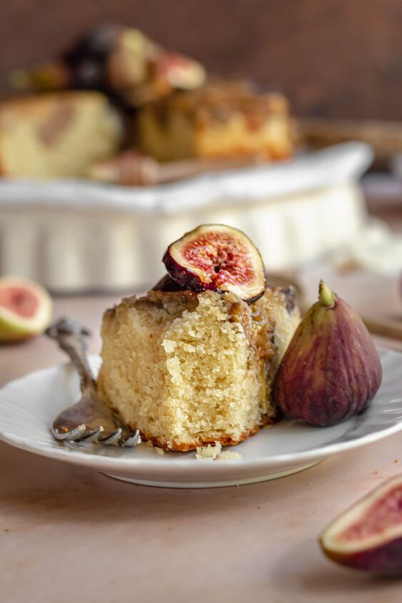 upside down almond fig cake, Fig cake on a plate with a fig on top and fork next to it A bite is removed