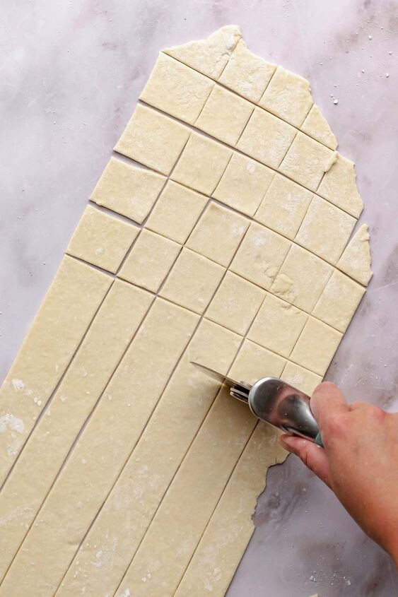 pennsylvania dutch chicken pot pie, A hand uses a pizza cutter to cut noodle dough