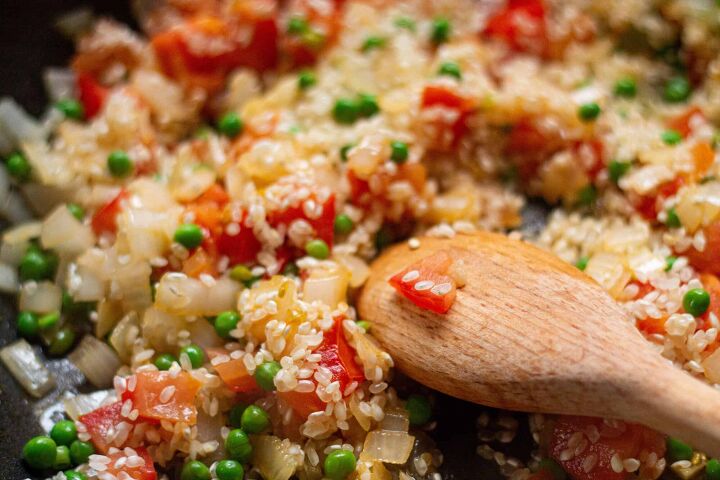 deliciously simple and tasty vegan paella, paella method adding the rice