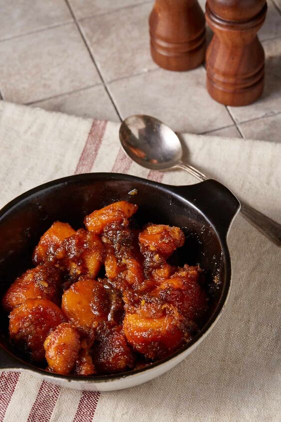 Candied yams in a serving dish next to a spoon