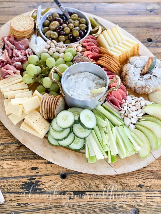 what we put on a fall charcuterie board, wooden board filled with cheese deli meats crackers and more for a fall charcuterie board