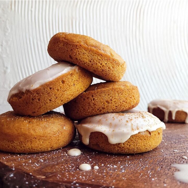 pumpkin donuts, functional image pumpkin cake donuts side view stacked some donuts have a white glaze and some do not background is white abstract