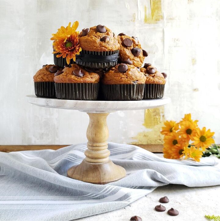 pumpkin donuts, functional image pumpkin chocolate chip muffins piled on a cake stand styled with orange flowers for fall