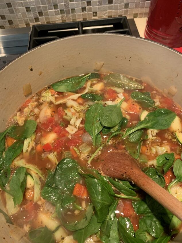 delicious ten vegetable soup, Here is the ten vegetable soup as it s simmering on the stove in a red soup pot The spinach leaves are on top and they look so vibrant