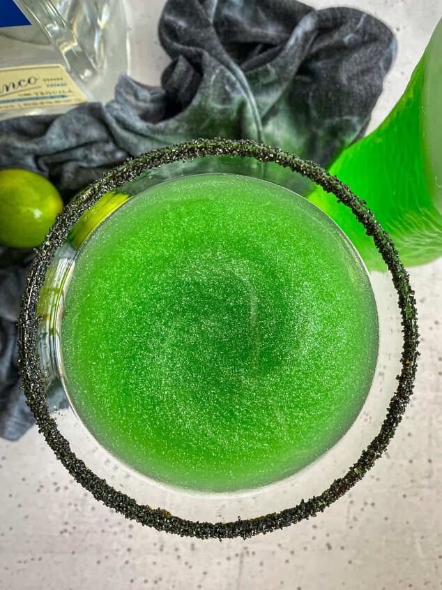 halloween margarita witches brew cocktail happy honey kitchen, Overhead view of a green glitter cocktail with a black sugar rim