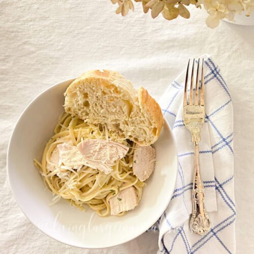 the best ever homemade swedish meatballs recipe, served easy homemade Alfredo sauce in a bowl with bread on the table