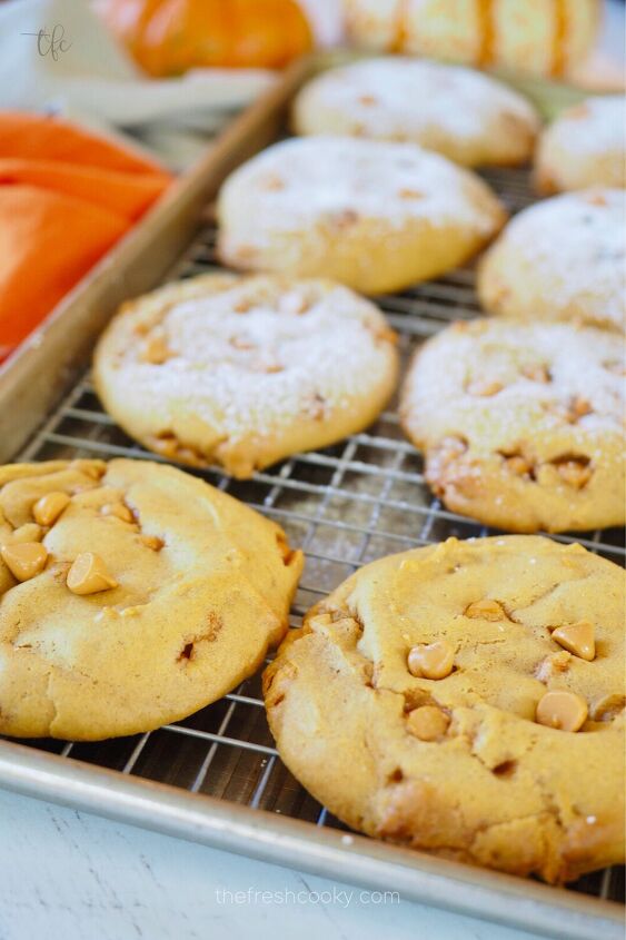 Soft pumpkin cookies with butterscotch chips on wire rack some with powdered sugar and some without