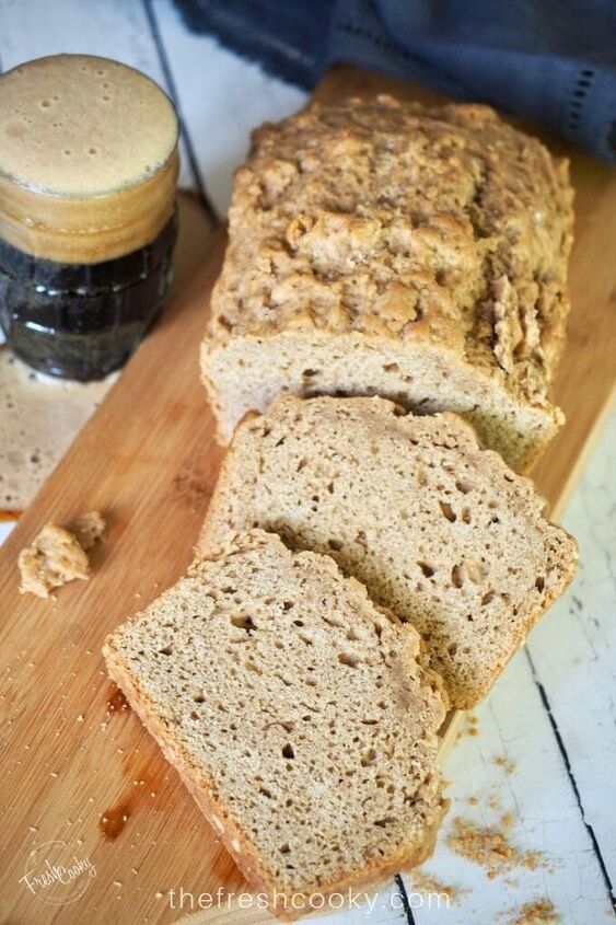 easy 4 ingredient beer bread, Top down shot of beer bread sliced on a cutting board with an overflowing glass of dark beer on the side