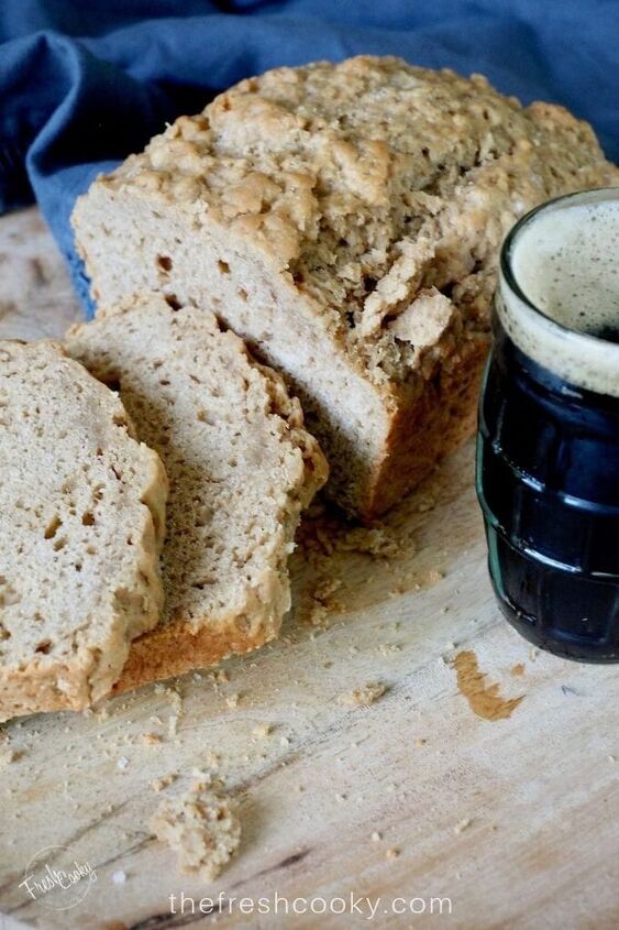 easy 4 ingredient beer bread, sliced beer bread with a mug of dark beer via thefreshcooky