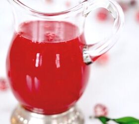 easy cranberry spritzer by the glass or pitcher, Image of small pitcher filled with cranberry simple syrup and frosted cranberries