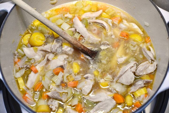 chicken and sourdough dumplings easy recipe , chicken soup in large pot with wooden spoon
