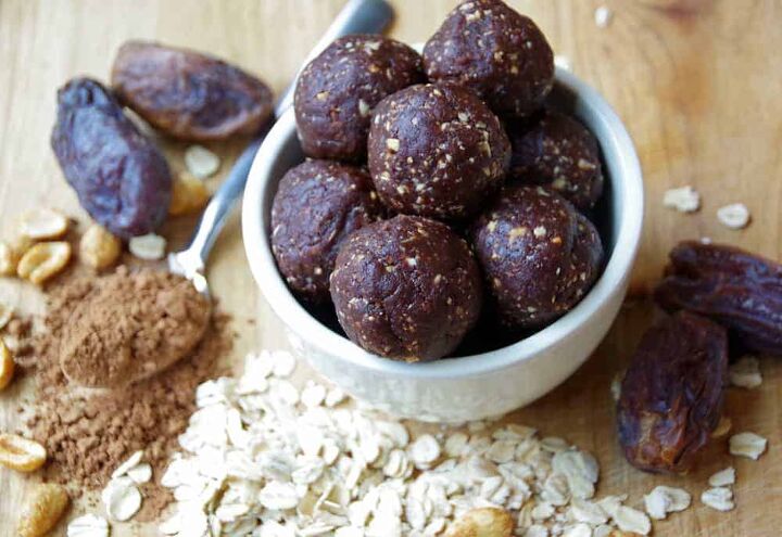Bowl of energy bites on cutting board with dates and oats