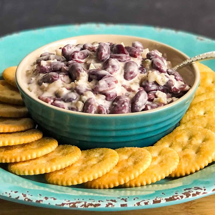 New England Bean Dip in a blue bowl with crackers in foreground