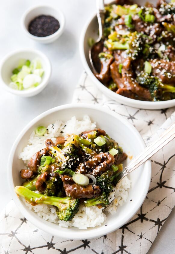 instant pot beef and broccoli, two bowls of Instant Pot Beef and Broccoli on a napkin garnished with sesame seed and green onions