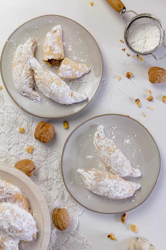 polish christmas cookies kifli, Two plates with Polish kiflies walnuts and powdered sugar on the table