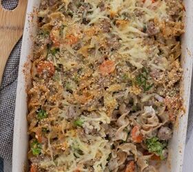 ground turkey broccoli noodle casserole, A beige stone rectangle baking dish filled with turkey noodle casserole It s browned on top with pieces of carrot and broccoli There s a wooden serving spoon next to the baking dish