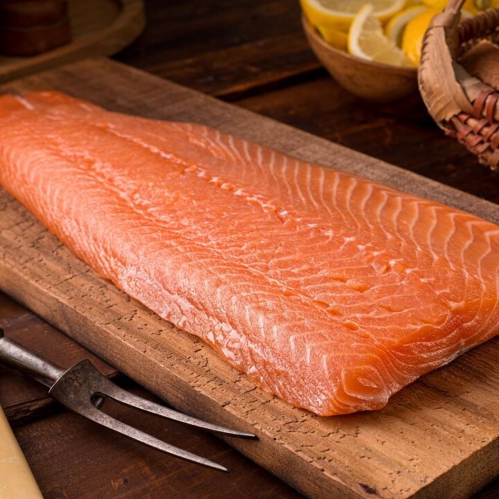 Raw side of salmon on chopping board
