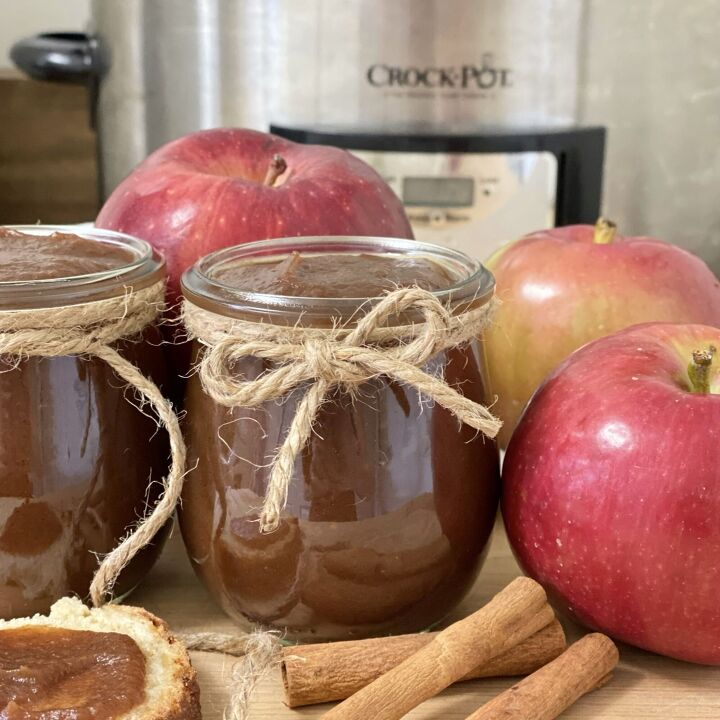easy crockpot apple butter, Easy crockpot apple butter in a jar with apples and cinnamon sticks in front of a crockpot
