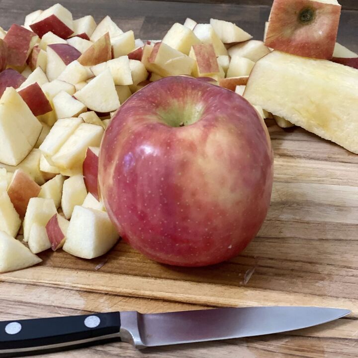 easy crockpot apple butter, A red apple pairing knife and chopped apples on a cutting board