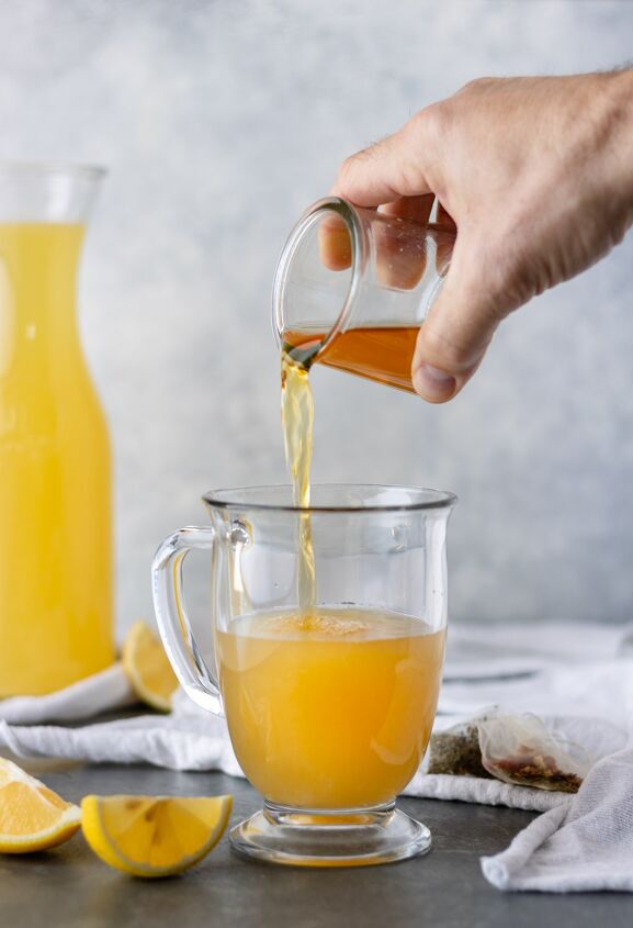 hot honey ginger tea with homemade lemonade, Pouring hot tea into a glass mug of steamed lemonade