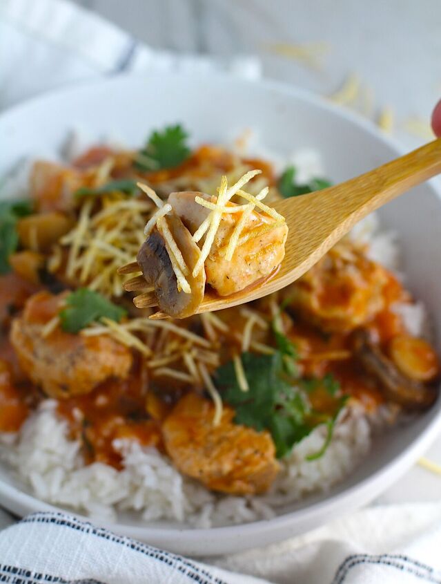 brazilian chicken stroganoff recipe, Fork holding bite of Brazilian Chicken Stroganoff in a tomato based sauce over a bowl with white rice with cilantro garnish and thin potato sticks on top This is an easy 30 minute dinner with a tomato based sauce cream and mushrooms all over rice