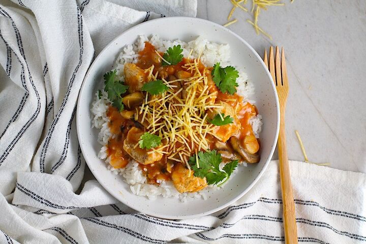 brazilian chicken stroganoff recipe, Brazilian Chicken Stroganoff in a tomato based sauce in a bowl over white rice with cilantro garnish and thin potato sticks on top This is an easy 30 minute dinner with a tomato based sauce cream and mushrooms all over rice