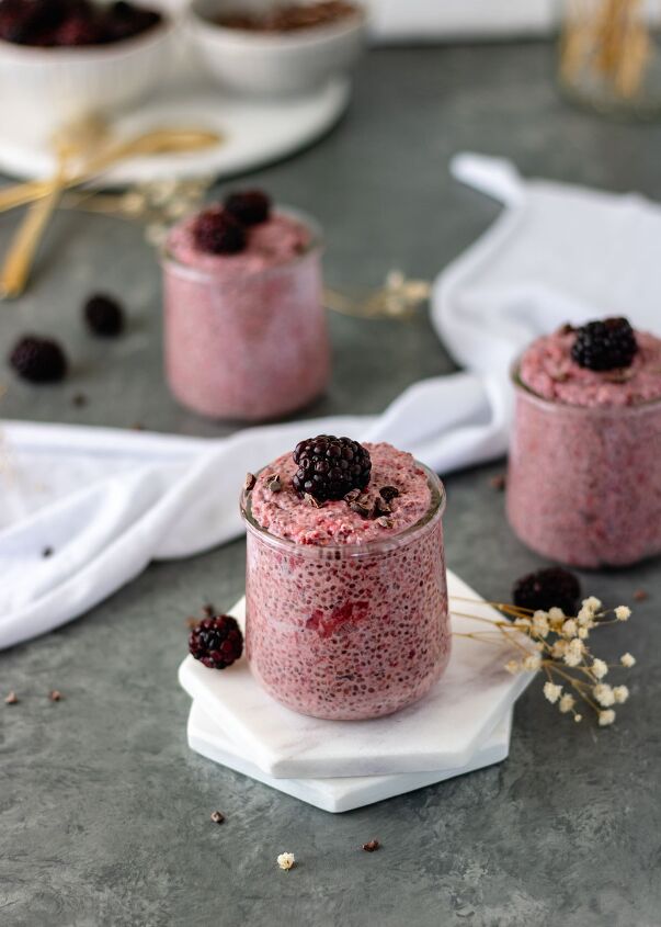 roasted strawberry chia pudding, Three mini glass jars of Roasted Strawberry Chia Pudding topped with cacao nibs and blackberries