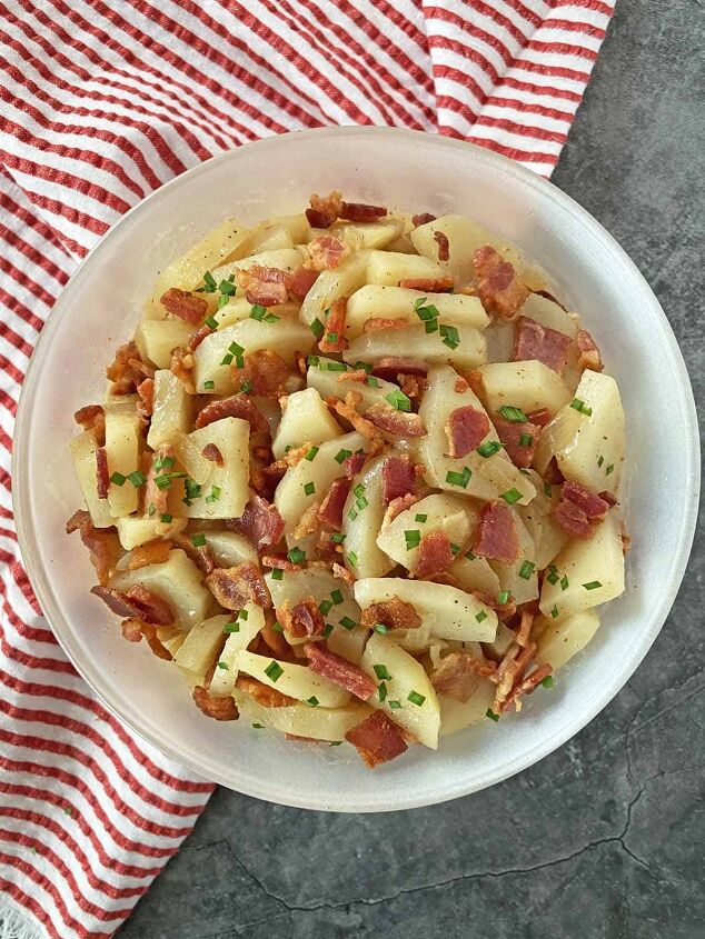 warm potato salad recipe with bacon, Warm potato salad in a white serving dish ready to eat with a red and white napkin tucked in on the left side